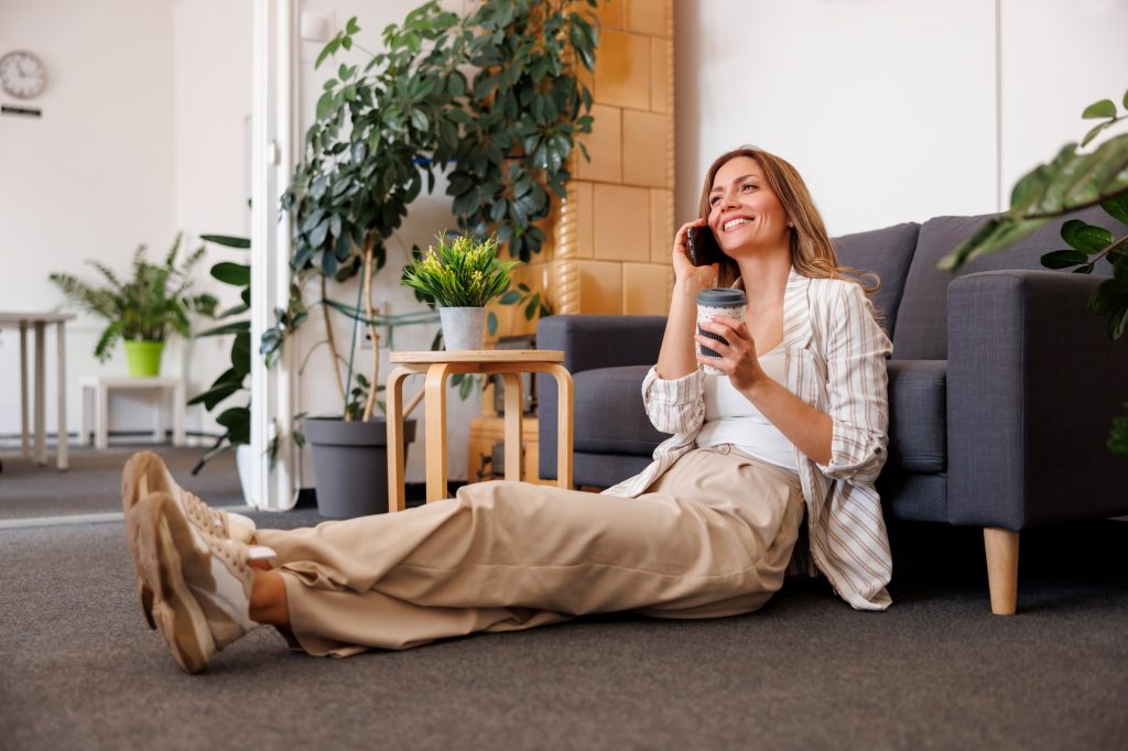Business woman having phone conversation while taking a coffee break