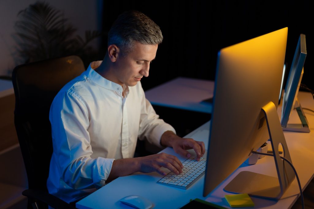 Focused Professional Working Late at Modern Office Desk